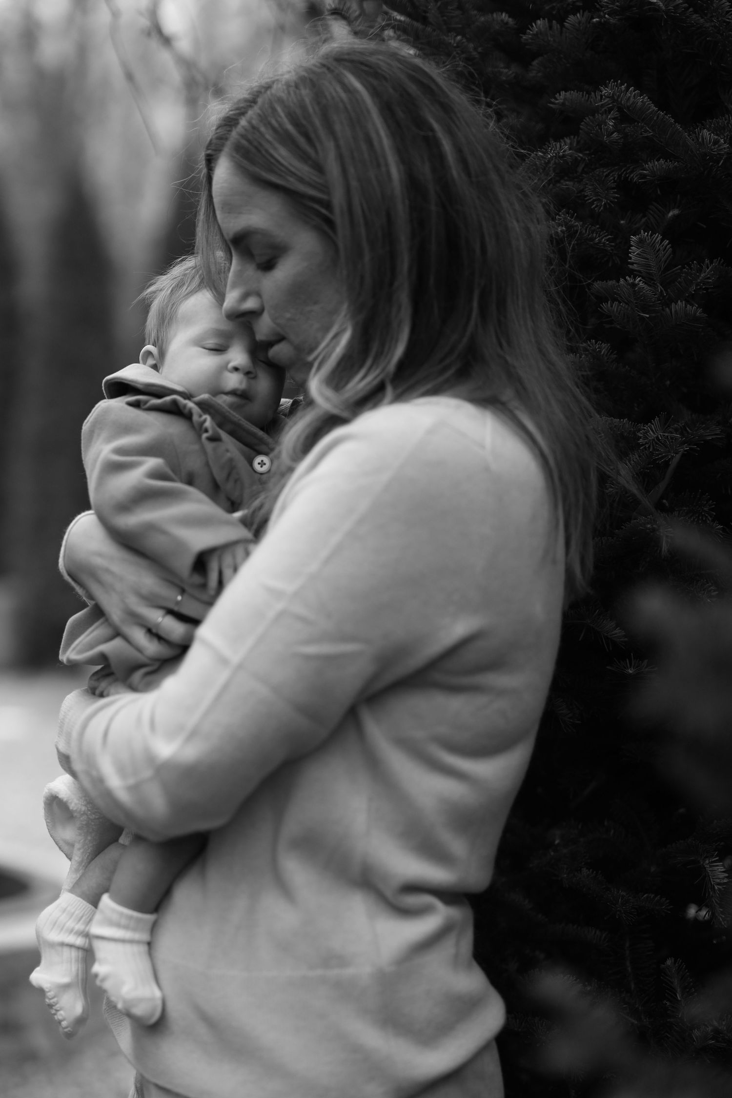 Mother Holds her baby tightly. Intimate moment between baby and mother, Black and white Portrait.
