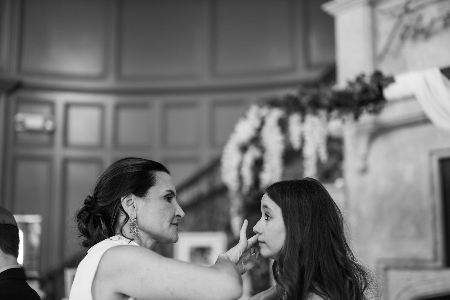 A black and white photo showing mother wiping away daughters tears at small wedding ceremony. Townhouse Restaurant  Greenwich Connecticut.