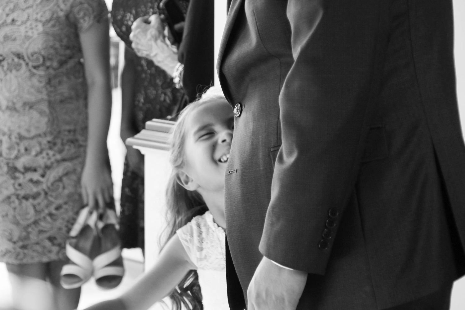 A candid black and white moment captured of a little girl's excitement at a wedding.