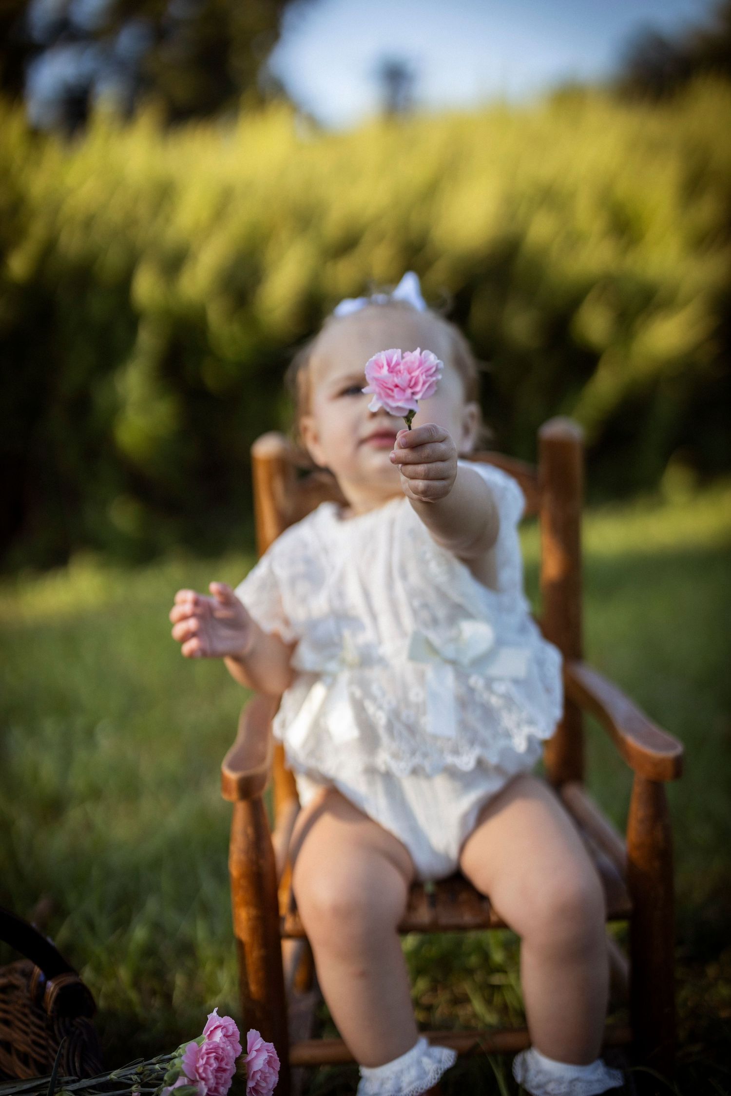 Baby holds up a daisy blocks that part of her face. Lots of depth of field.