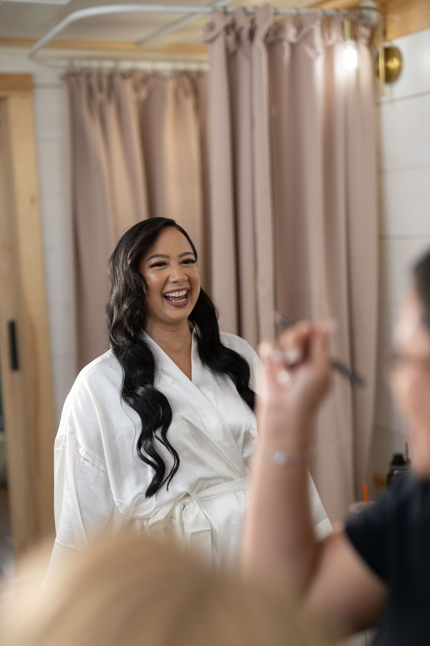 Portrait of a bride smiling while getting her makeup done up