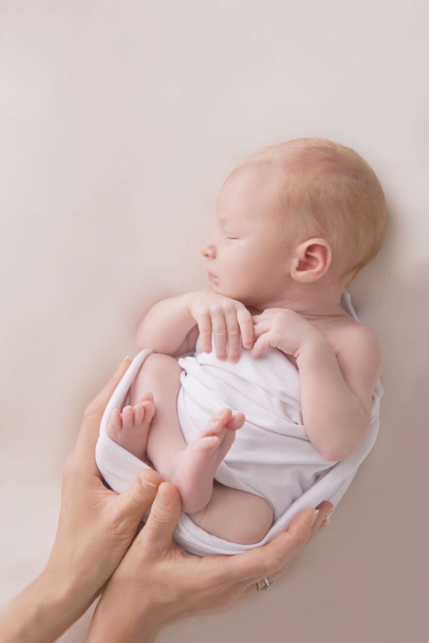 Soft newborn wrap around a newborn baby during  an in-home photography in Bakewell.