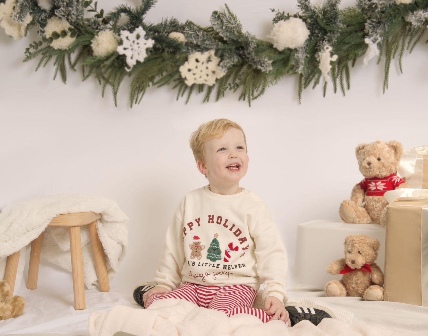 Christmas session portrait of a 3 year old boy smiling in a mobile studio in Clay Cross.