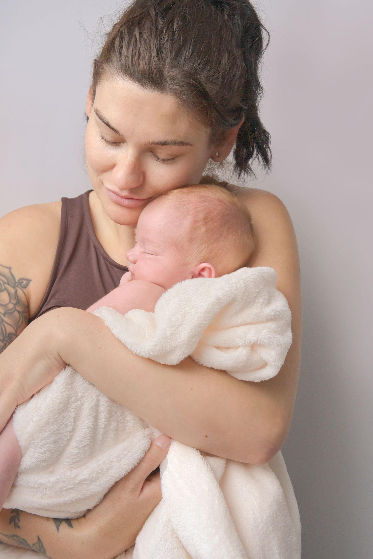 Mother holding her newborn baby during an in home photoshoot in Poolsbrook