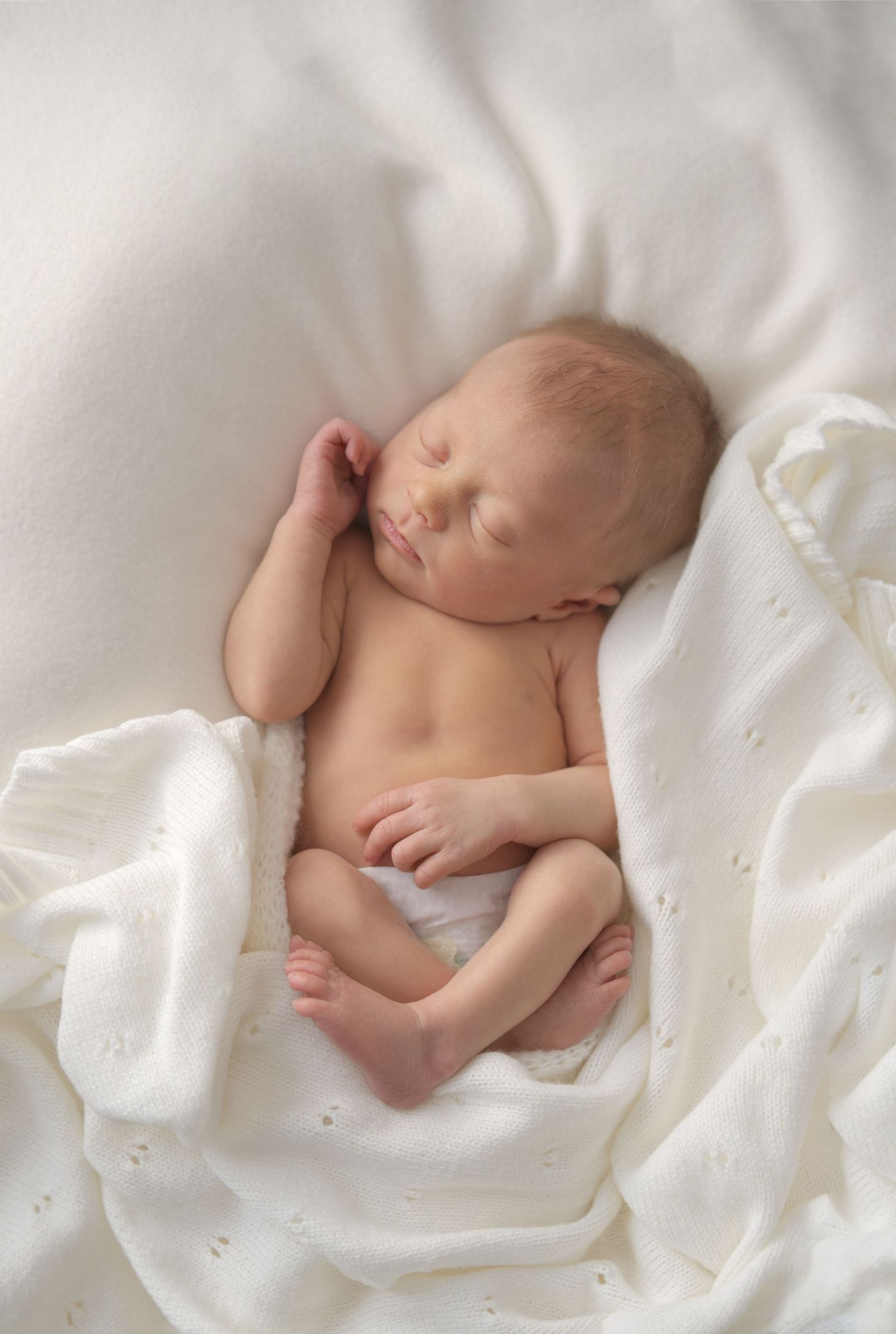 Newborn baby sleeping soundly during a professional in-home photography session in Chesterfield.
