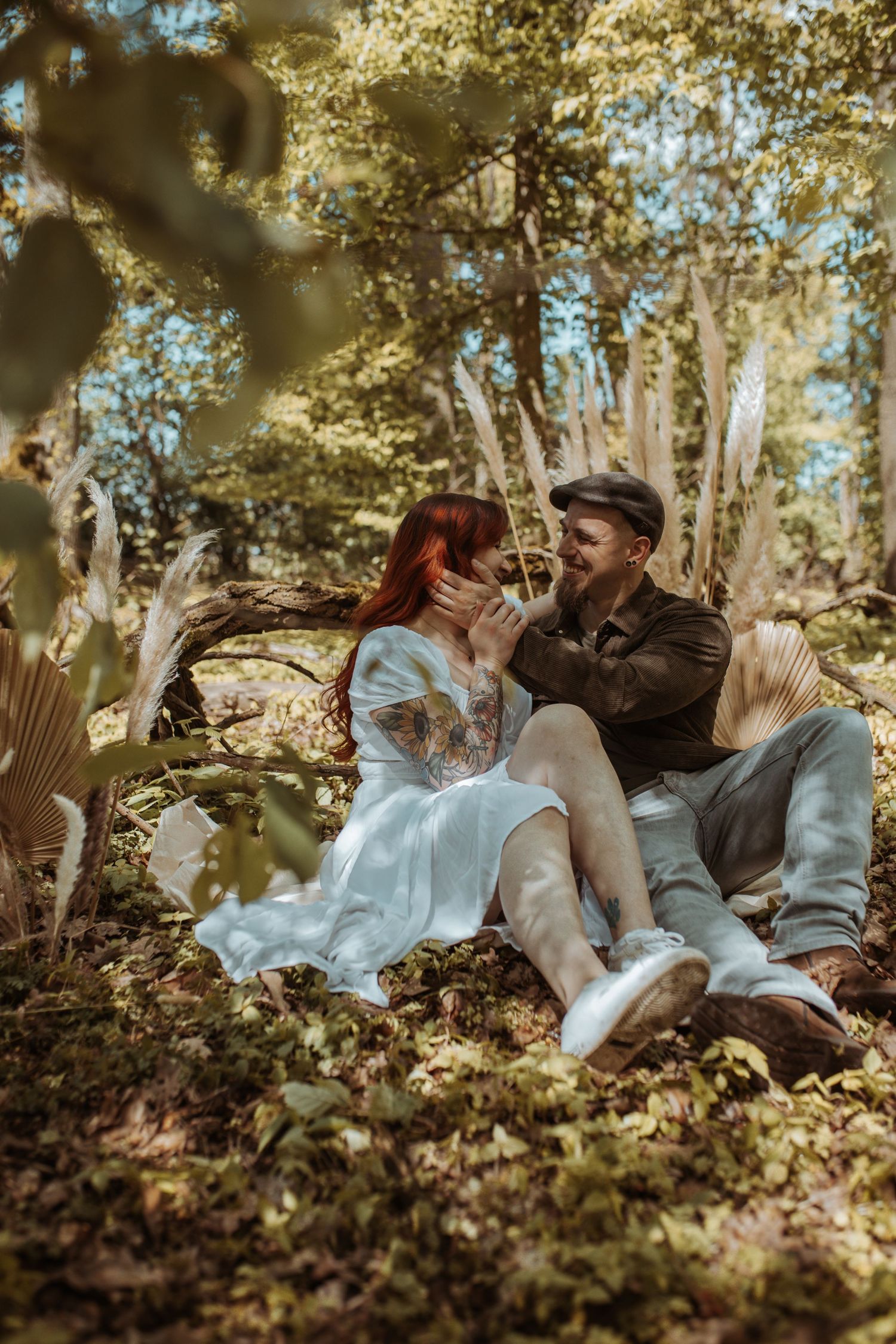 Couple sitting together in a sunlit forest, sharing a tender moment.