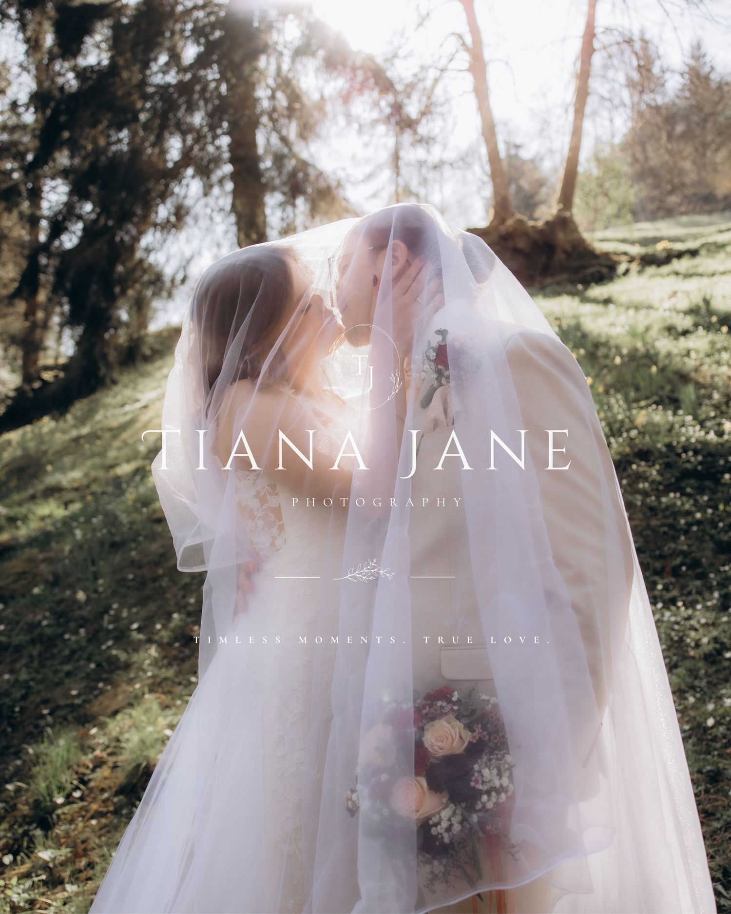 Two brides share a romantic kiss under a flowing veil outdoors, captured by Tiana Jane Photography.