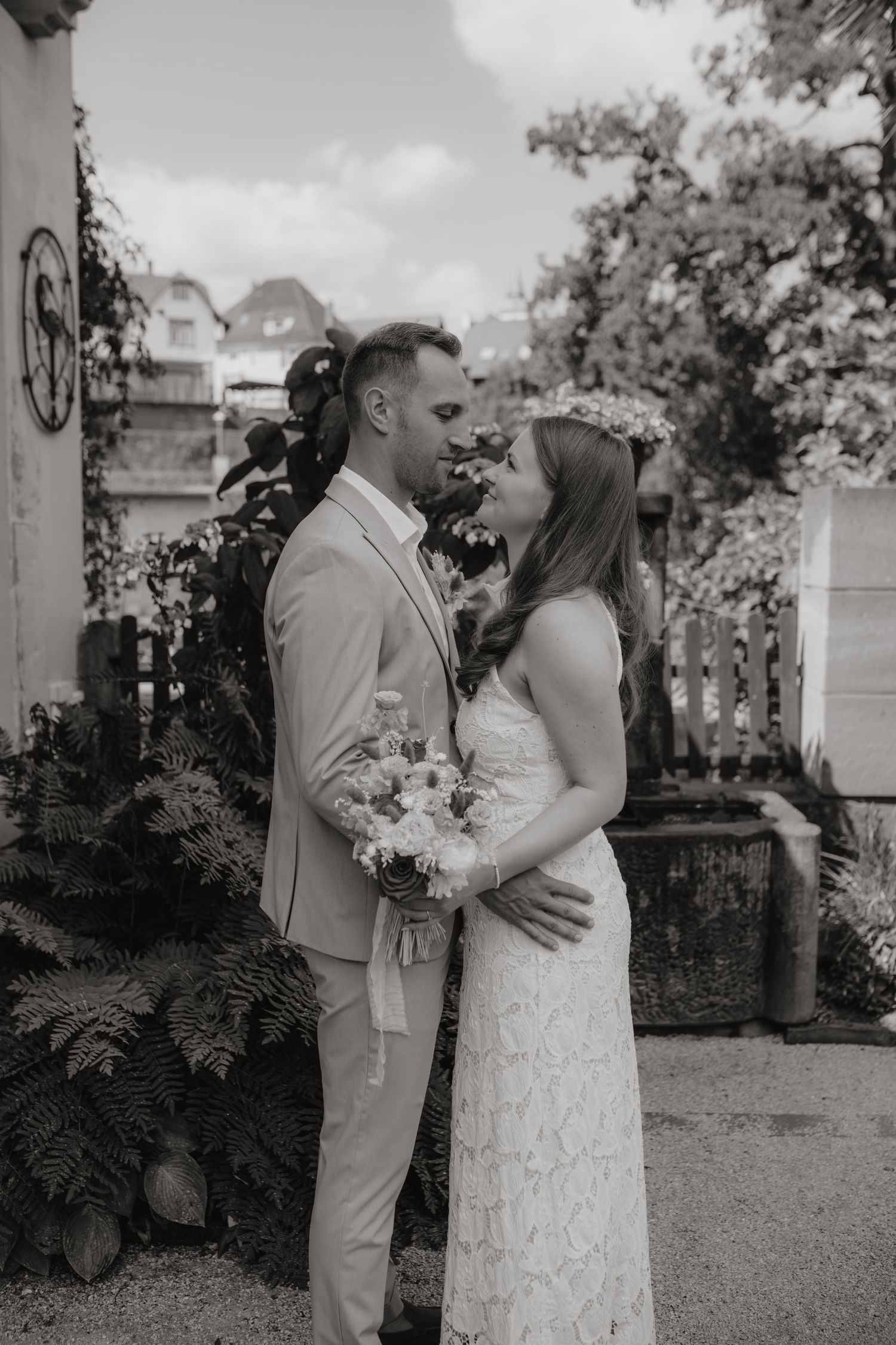 Black and white photo of a bride and groom sharing an intimate moment outdoors on their wedding day.