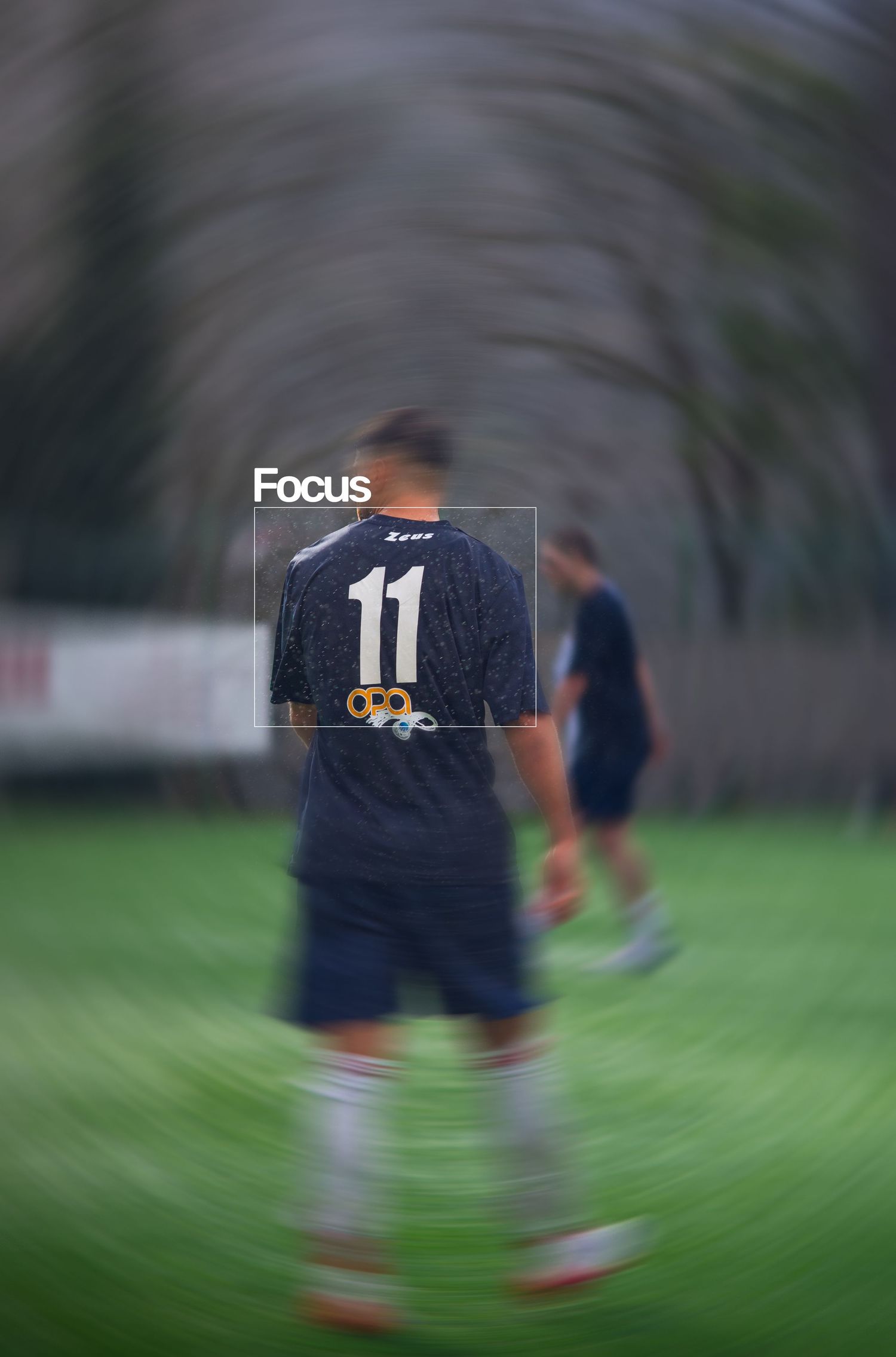 Soccer player wearing number 11 jersey on a green field, with motion blur effect and focus text overlay.