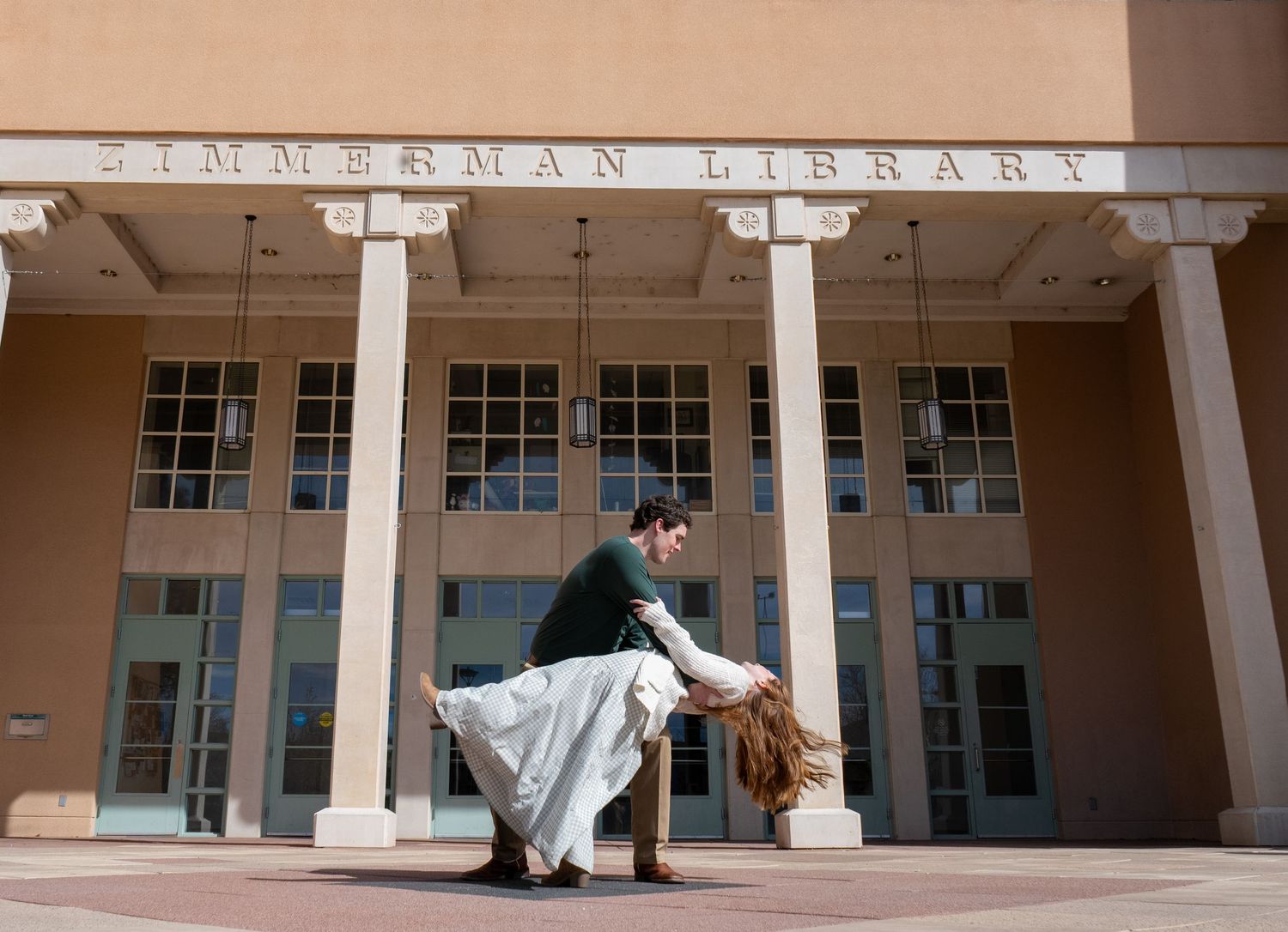a couple doing a dance dip in front of a nice building
