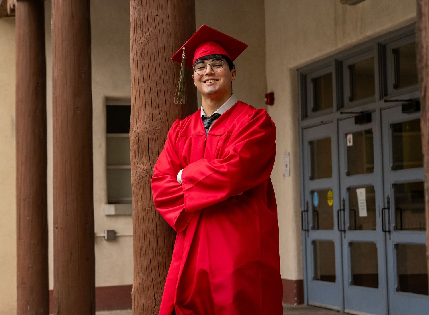 a unm graduate leaning on a pole
