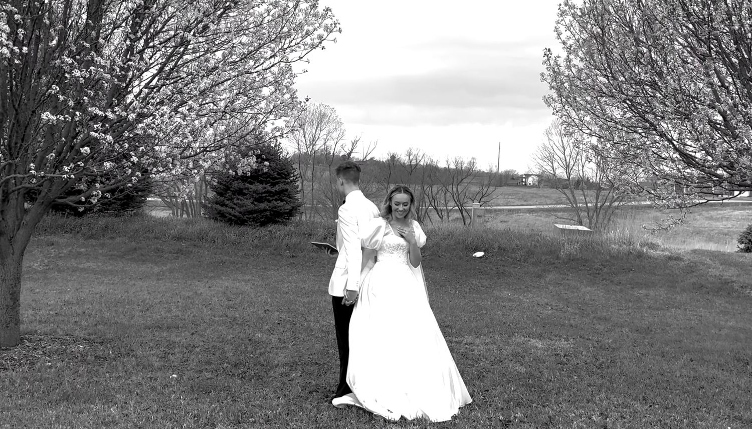 Bride and groom posing together outdoors on their wedding day.