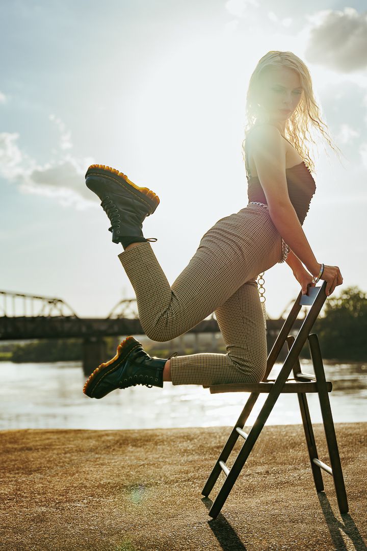 A sequence of shots showing a person in beige clothing sitting on a wooden chair at sunset by the water.