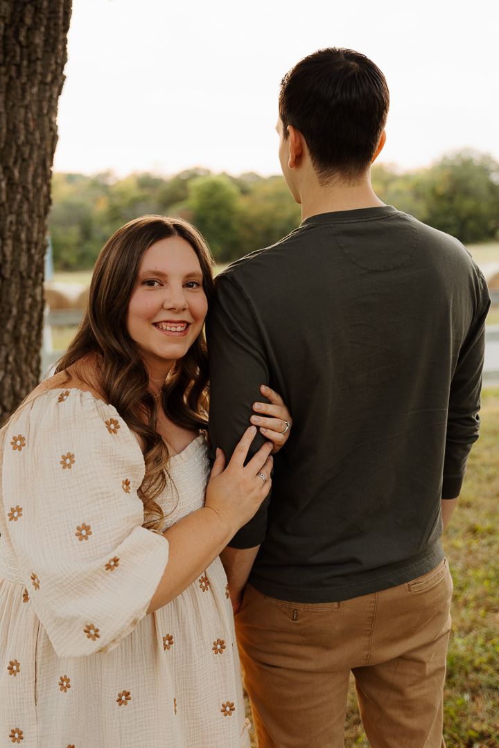 Candid maternity photography showing playful moments between an expectant couple outdoors.