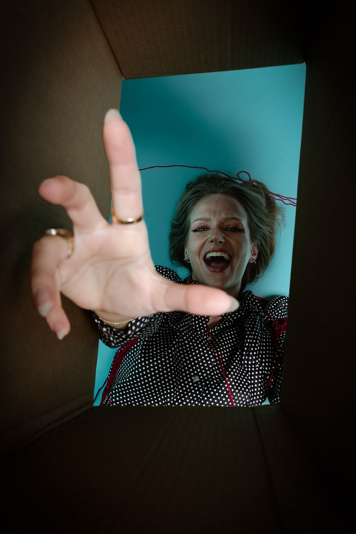 Creative wide angle shot showing hands reaching toward camera with teal background.