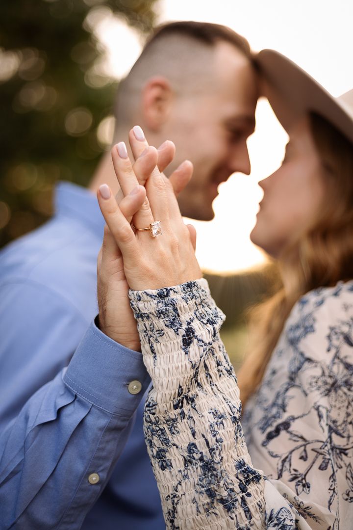 A series of tender hand-holding moments between a couple against a sunset background wearing blue and floral clothing.