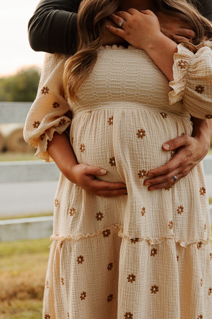 Close-up series of maternity photos showing a pregnant belly in a cream-colored dress with small floral embroidery details.