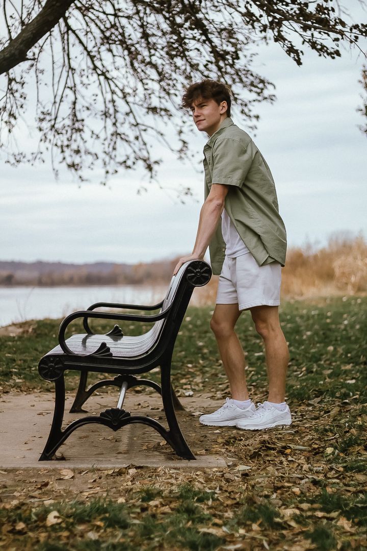 Artistic series of close-up shots showing sneakers and a black park bench surrounded by fallen autumn leaves on a cloudy day.