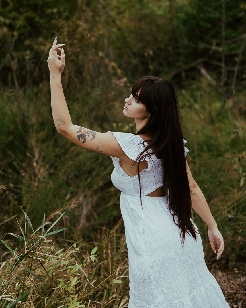 Expressive dance-like poses captured in a natural setting with tall grass and autumn foliage.