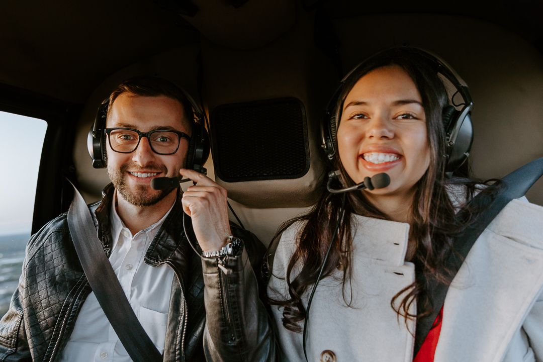 Three people laughing together while riding in a car interior.