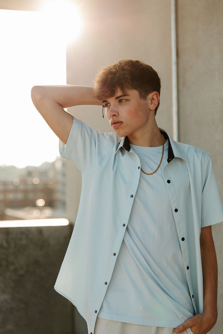Artistic photo series of person in white button-down shirt posing against soft natural lighting and urban backdrop.
