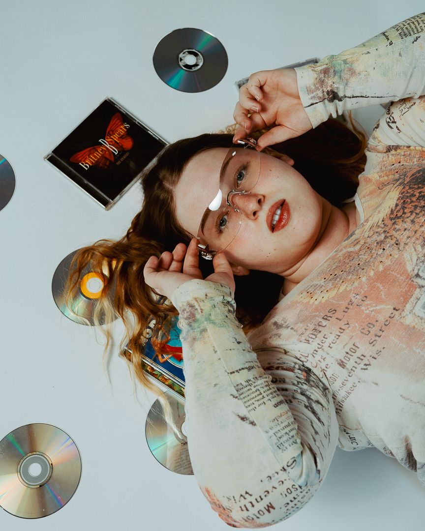 Artistic photo series with CDs and vintage-inspired fashion against white backdrop.