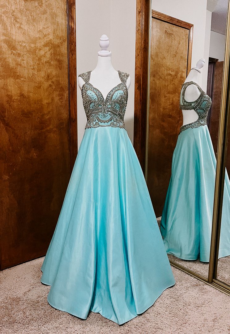 Elegant aqua blue satin ballgown with beaded bodice and open back displayed on mannequin, perfect for prom or formal events.
