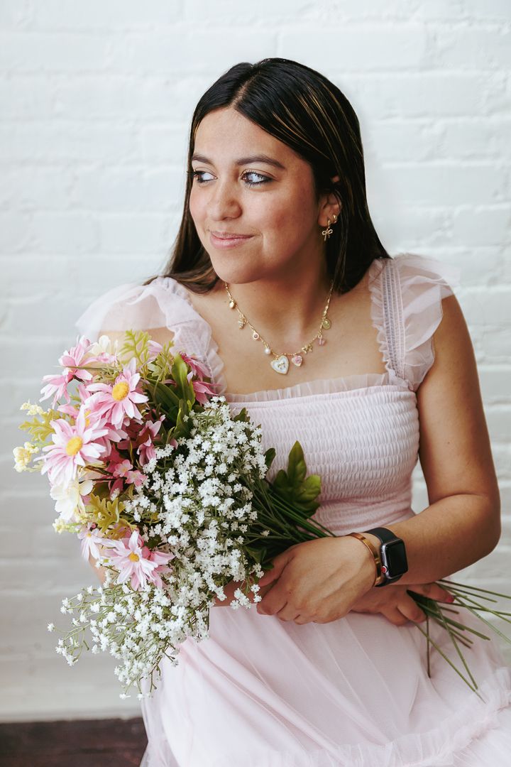 A series of photos shows someone in a pink dress holding a fresh bouquet of pink daisies and baby's breath.
