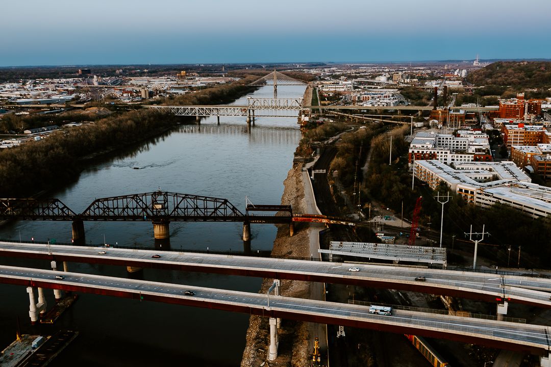 Aerial view of multiple bridges crossing a river in an urban cityscape.