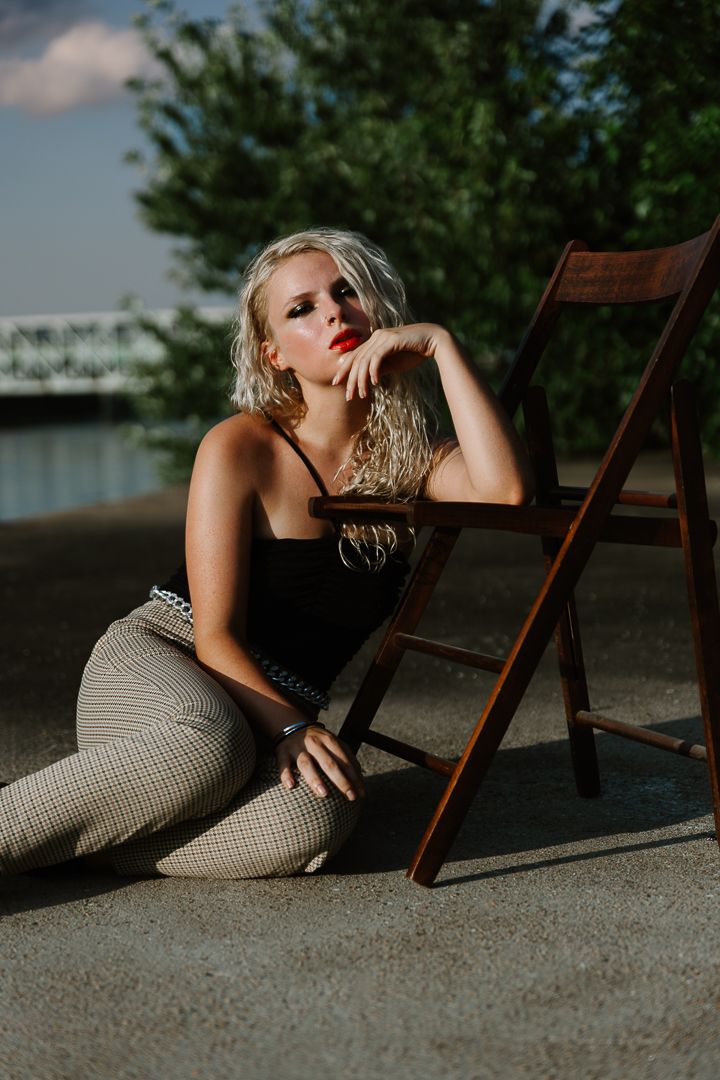 Moody fashion photography sequence featuring dramatic poses with a vintage wooden chair on concrete at sunset.