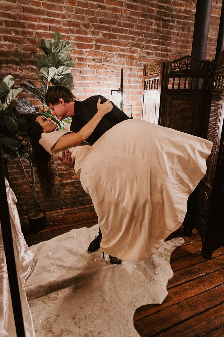 A sequence of dance movements captured against a rustic brick wall backdrop showing flowing white fabric in motion.