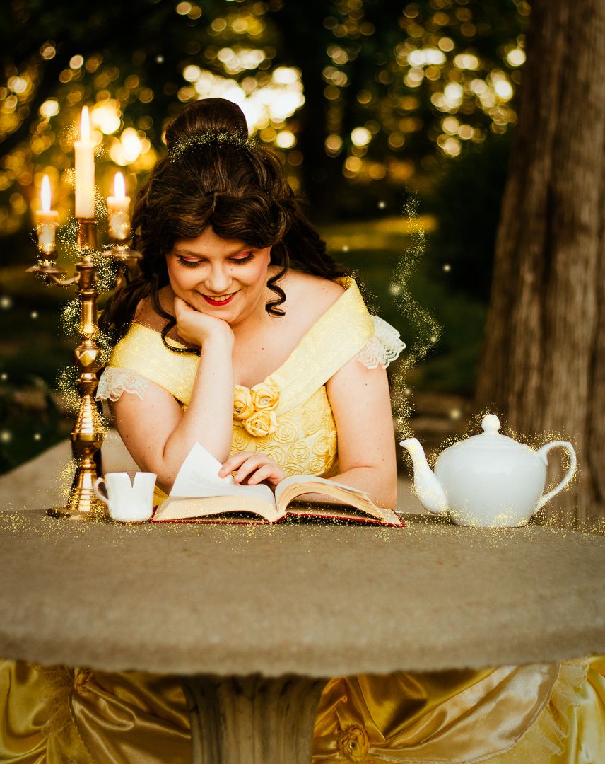 Vintage tea party scene with candles and teapots on rustic wooden table.