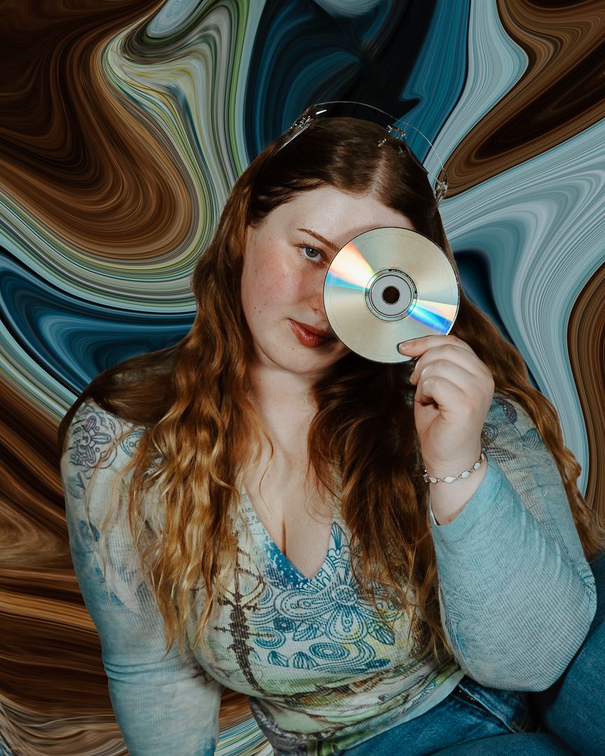 Artistic portrait with swirling blue and brown effects featuring someone holding a CD.