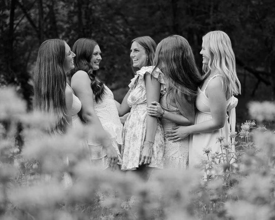 Black and white panoramic photo showing four intimate moments between couples embracing in a dreamy outdoor setting.