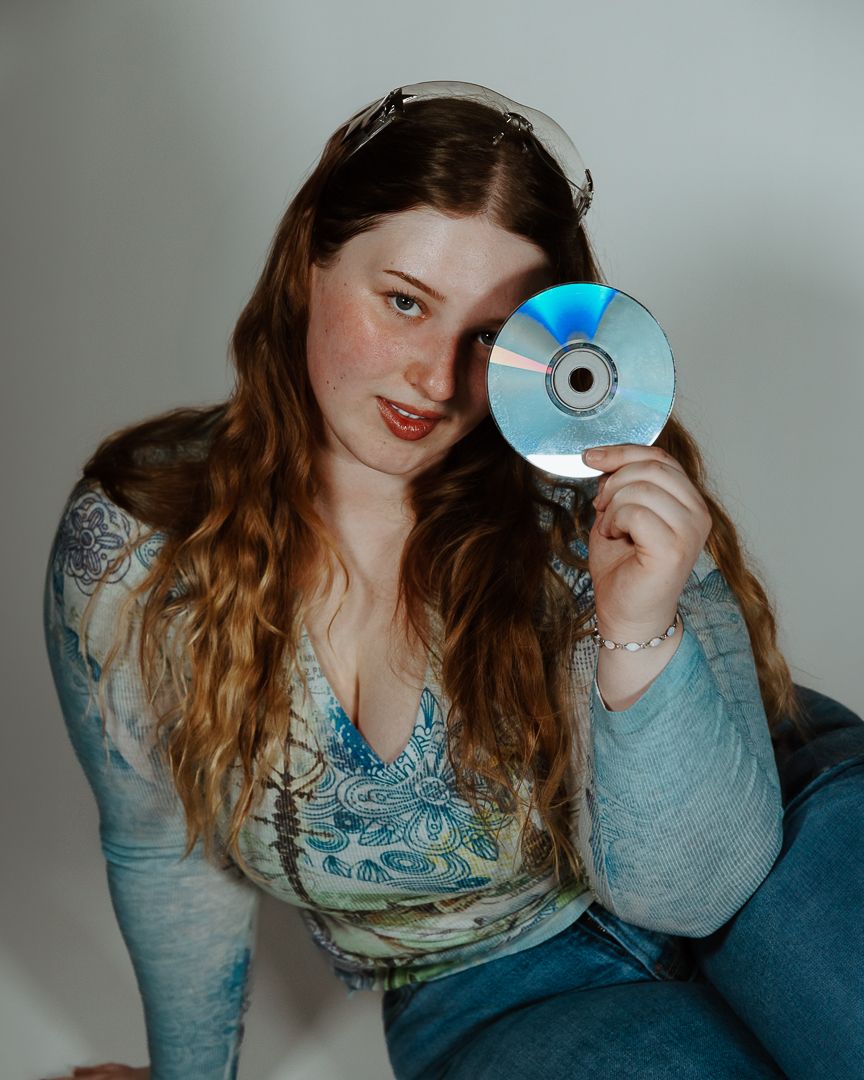 Artistic self portrait series featuring compact discs held at different angles in a soft-lit setting.