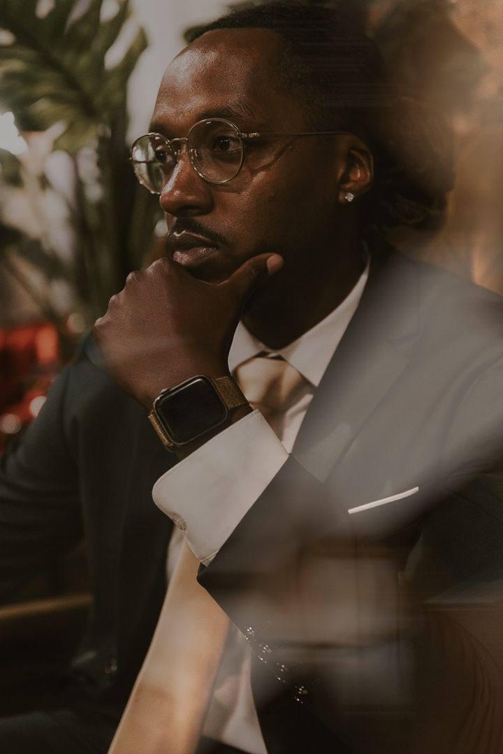 Close-up profile portraits of a person wearing glasses and a white dress shirt in warm, moody lighting.