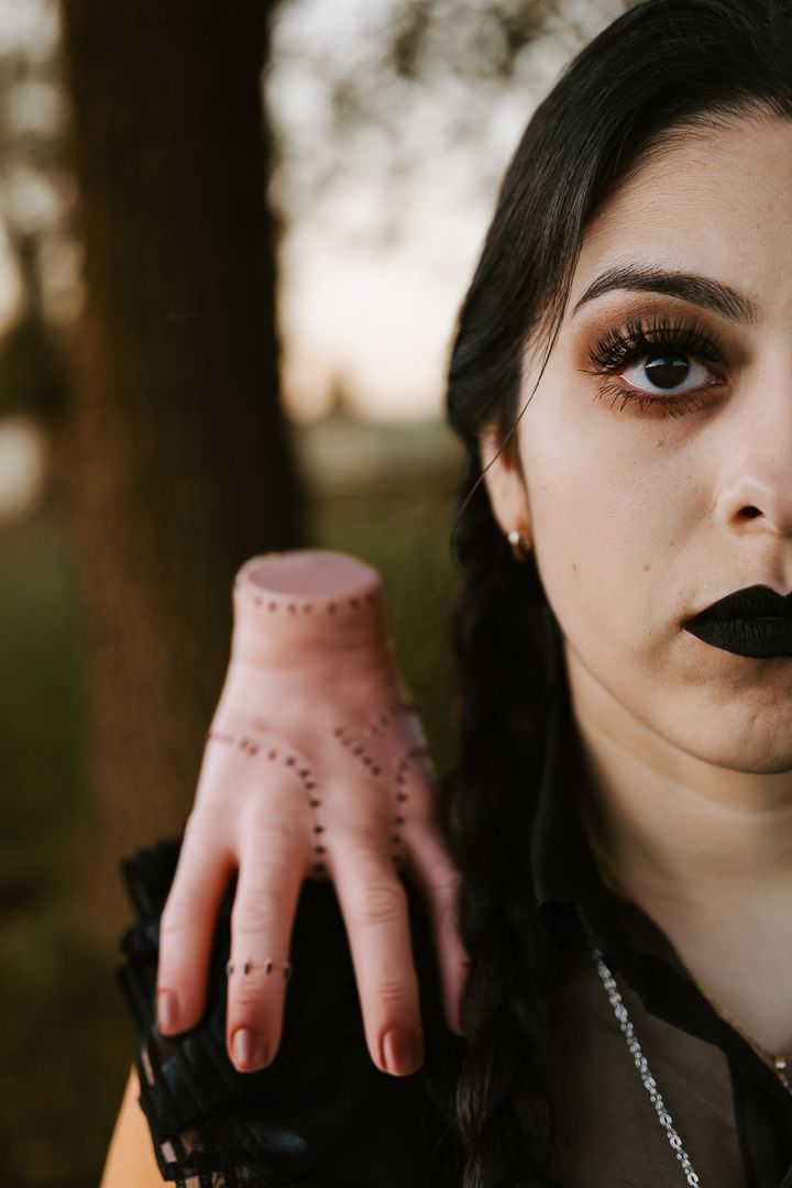 Artistic portrait featuring dotted hand patterns and dark lipstick in a moody lighting setup.