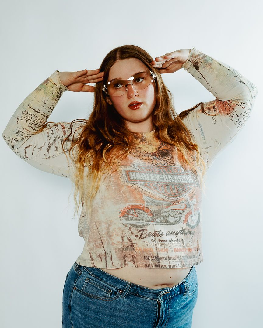 Fashion model in faded graphic tee and denim jeans poses against white background in four casual studio shots.
