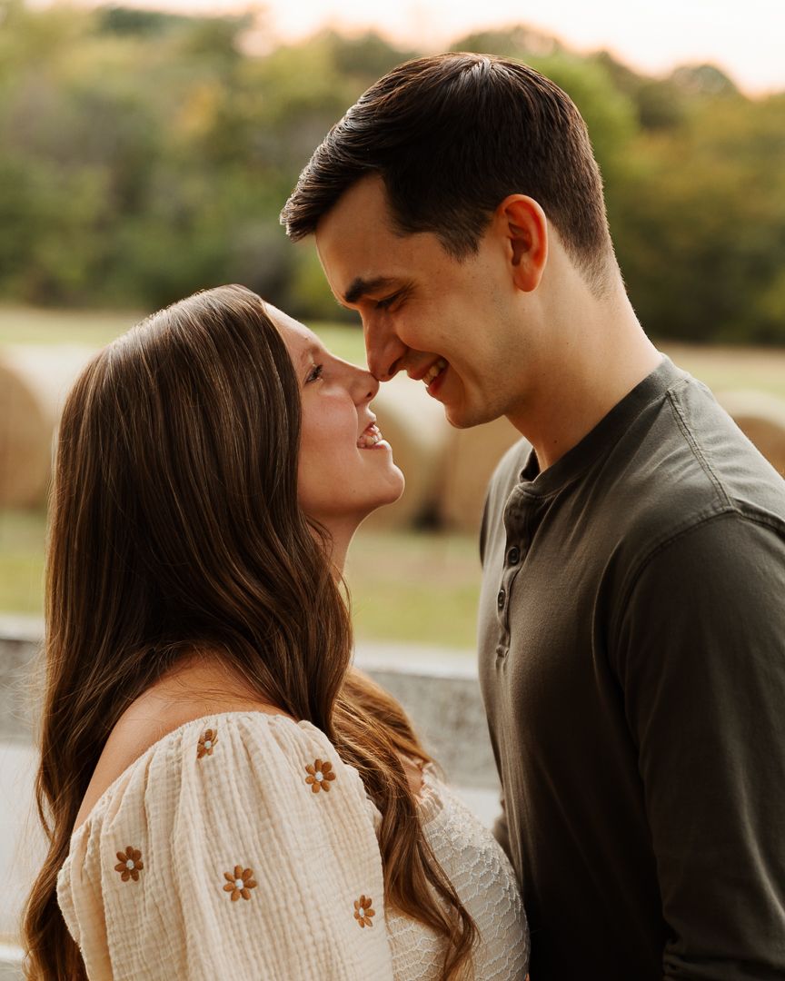 Romantic sunset maternity photos of a couple embracing outdoors.