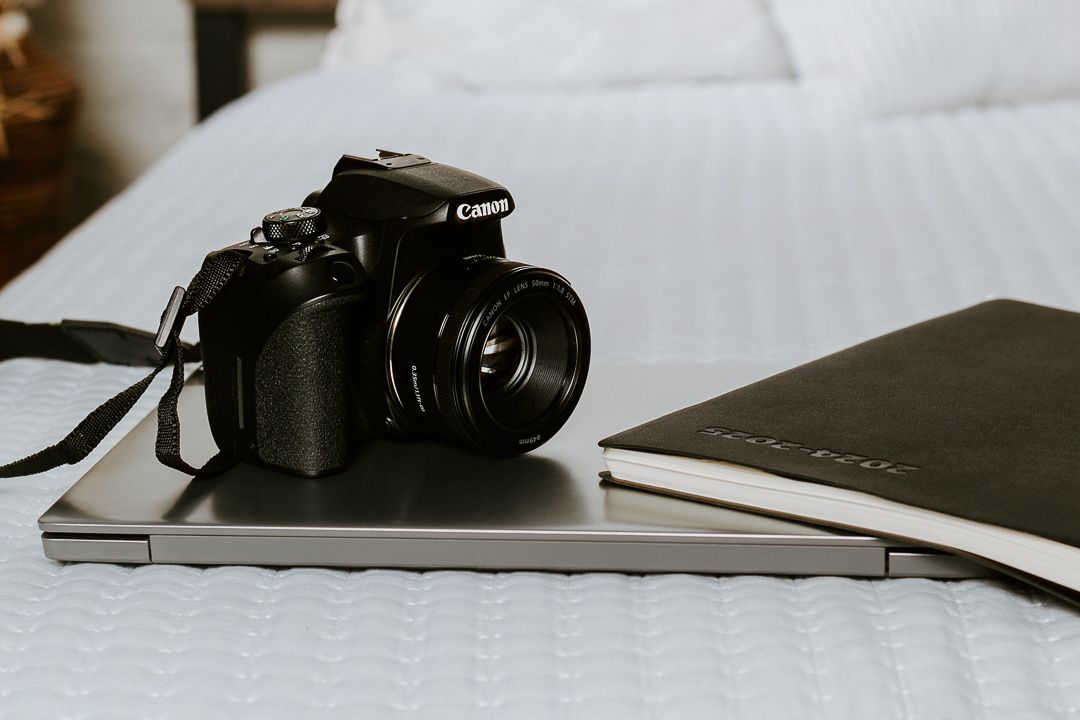 Close-up view of a black DSLR camera on a white surface showing different angles and details.