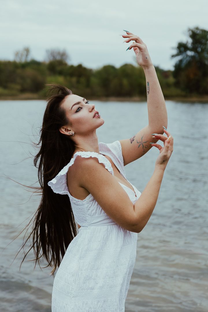 A series of artistic dance poses in a white dress by the water, showing graceful movement and expression.