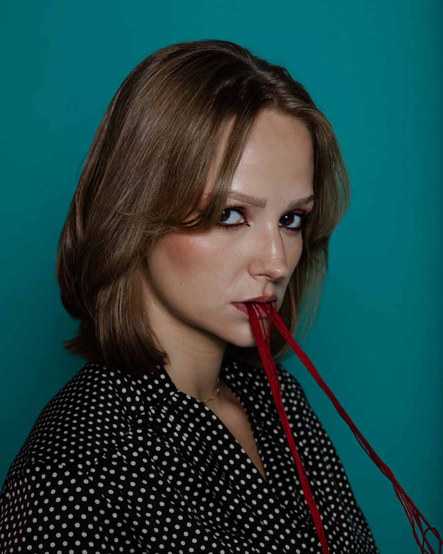Creative fashion portraits with red string props and polka dot styling against turquoise backdrop.