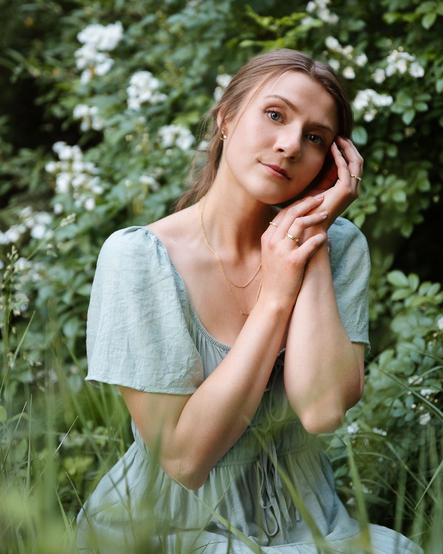 Light blue dress captured in ethereal outdoor portraits with flowering plants and dreamy natural lighting.
