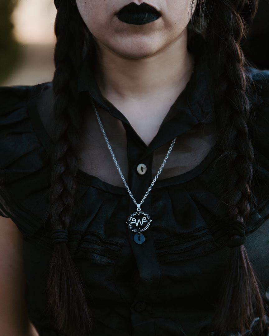 Close-up shots showing dark lipstick and gothic style silver necklaces against black clothing.