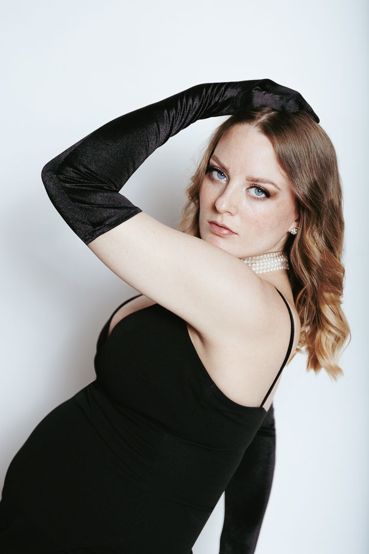 Fashion portrait series featuring a model in black long sleeve dress posing against white studio backdrop.