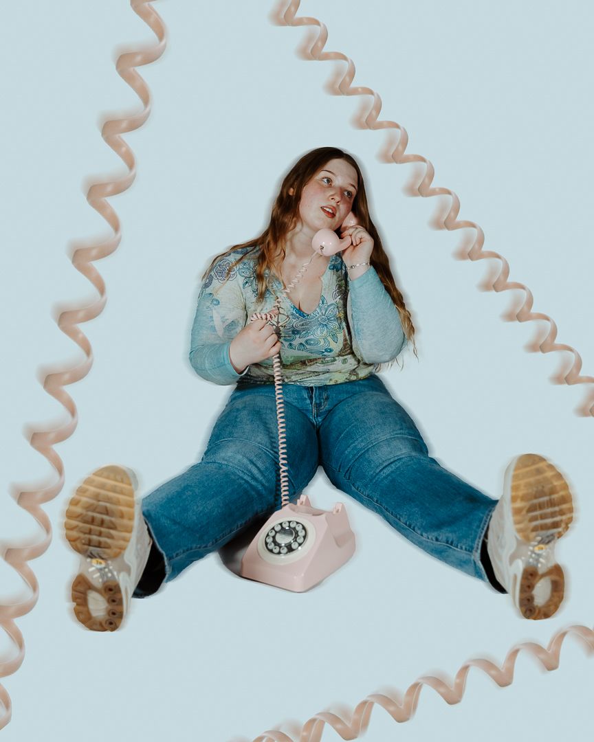 Playful floor poses with retro telephone cord frame and denim outfit styling.
