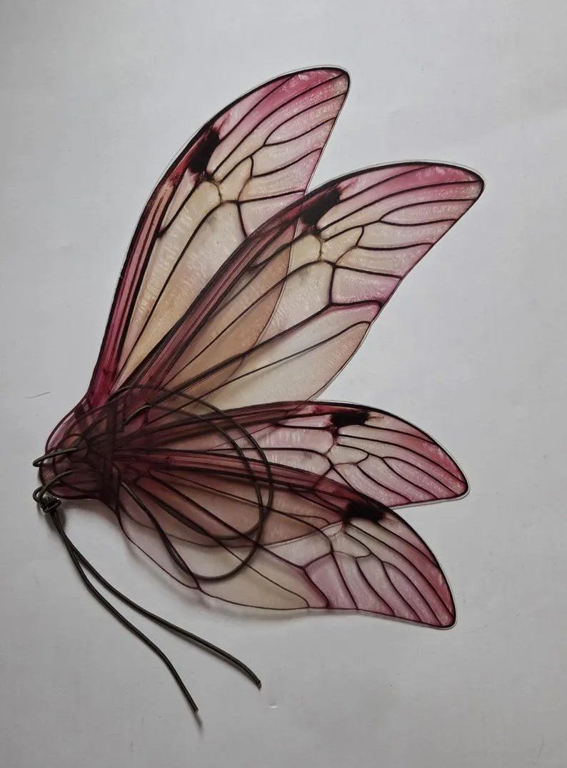 Handmade translucent fairy wings with pink and burgundy veined cicada-style panels and wire frame, displayed on a plain light background.