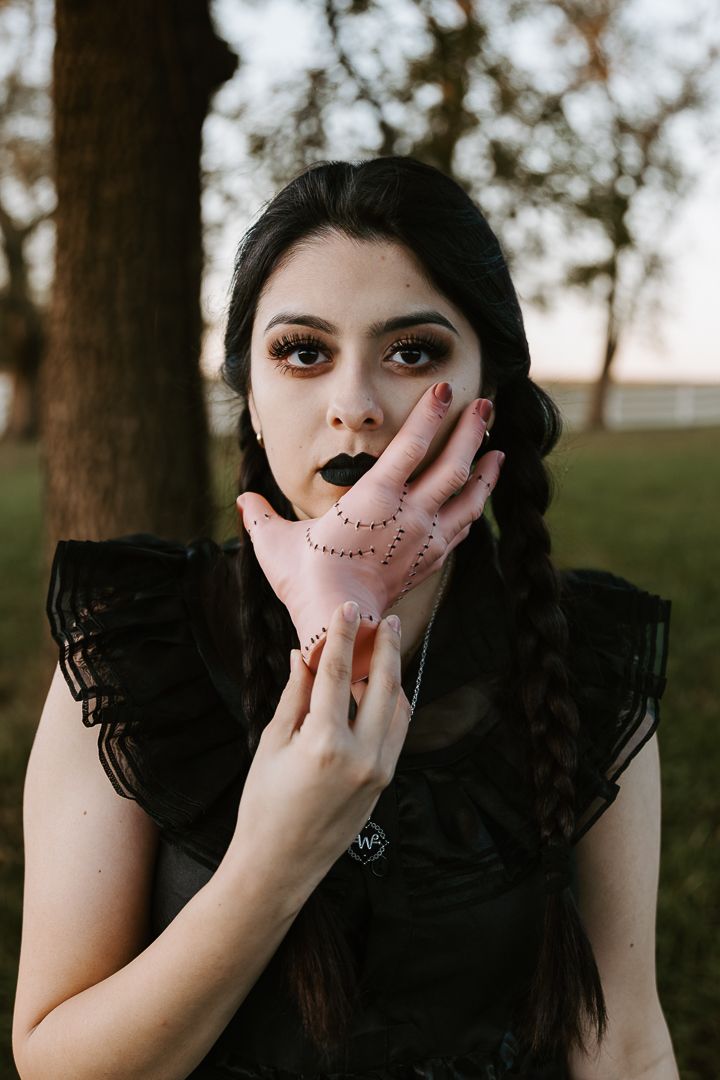 A series of artistic portraits showing dark-haired figure with dotted makeup in black dress against outdoor background.