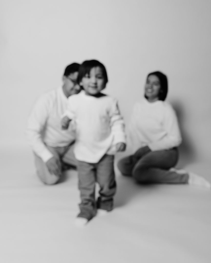 Black and white photography series showing a toddler in different playful reclining poses on a white background.