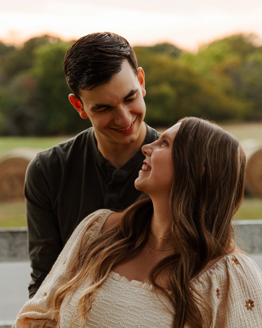 Loving couple sharing intimate kiss during sunset photo session in nature.